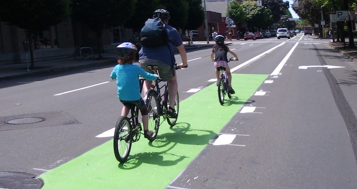 Family rides in a green bike lane
