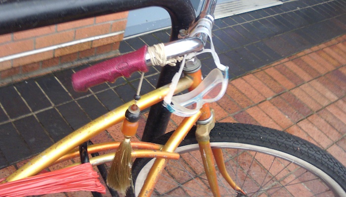 Goggles hanging off of a bicycle handlebar