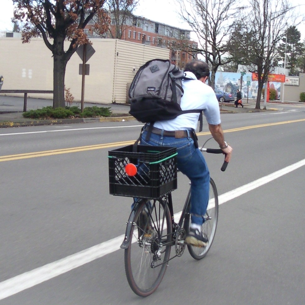 Man riding crate bike with big backpack