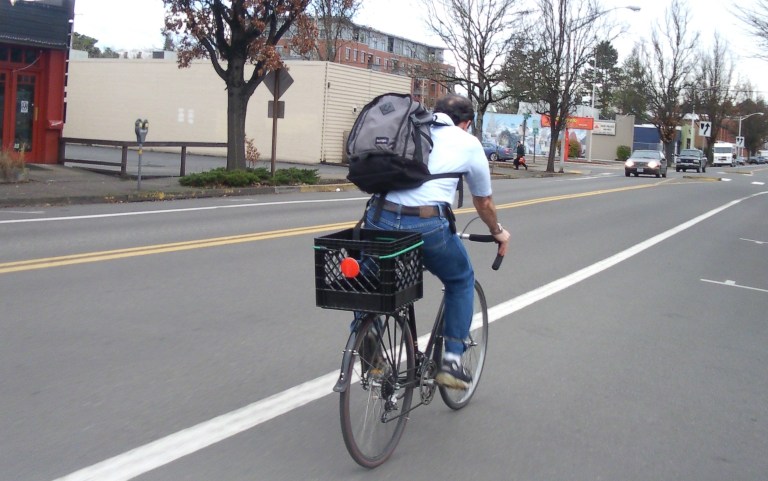 Man riding crate bike with big backpack