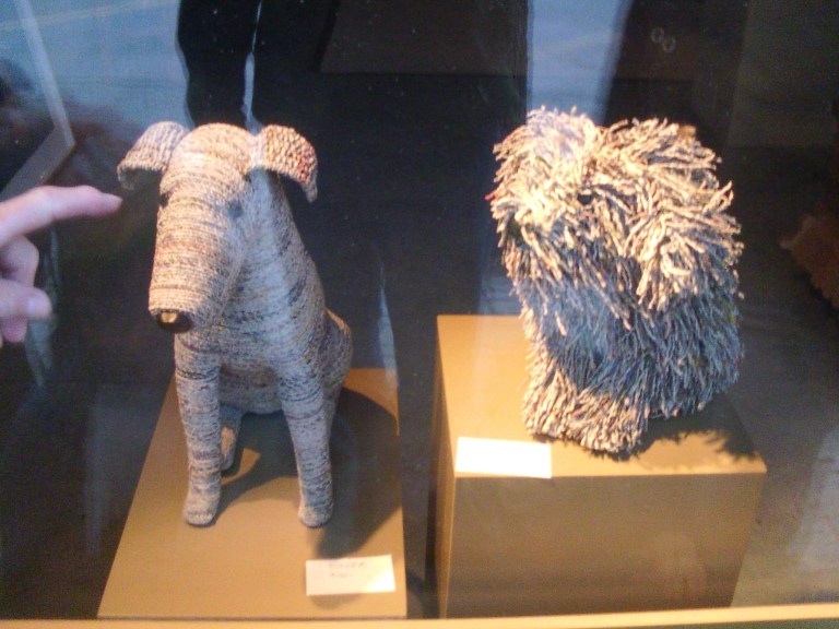 Photo showing dog sculptures that are made from twisted pieces of newspaper.